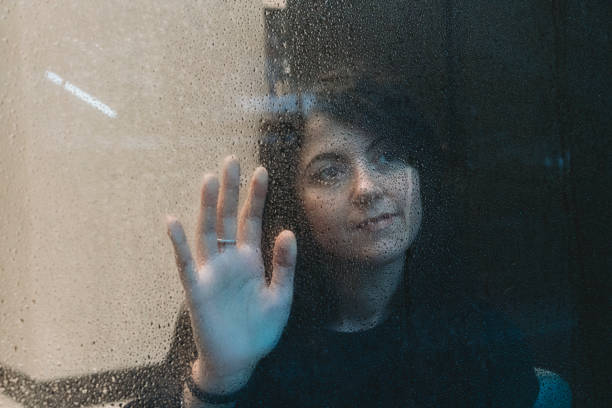istock Pensive woman looking from a shop window on a rainy day 1027761814