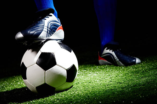 istock Black and white soccer ball with foot stood on it 102776190