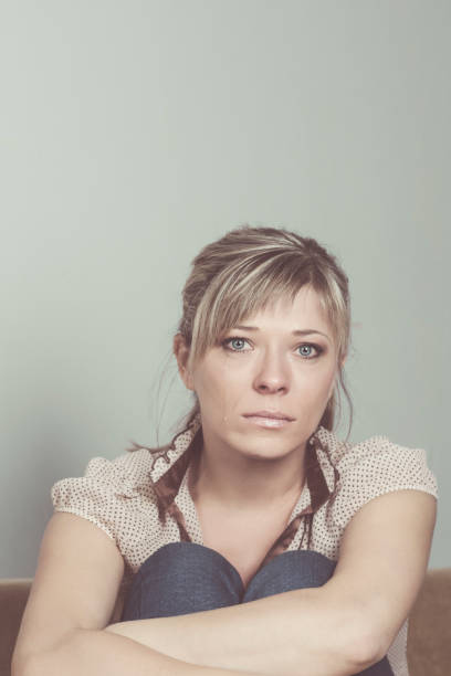 istock Woman Suffering From Depression Sitting On Bed And Crying 1027761934