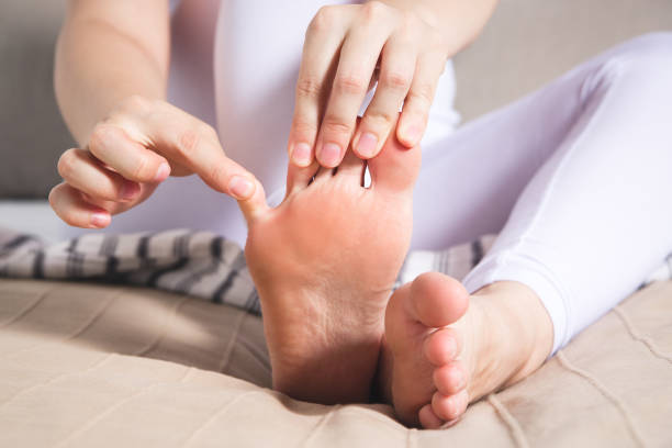 woman's leg hurts, pain in the foot, massage of female feet - reflexology pedicure massaging human foot imagens e fotografias de stock