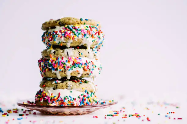 Summer isn't over! Celebrate with these cookie ice cream sandwiches. Rainbow sprinkles and vanilla ice cream. All balanced gracefully, and meltily, on pink depression era glass!