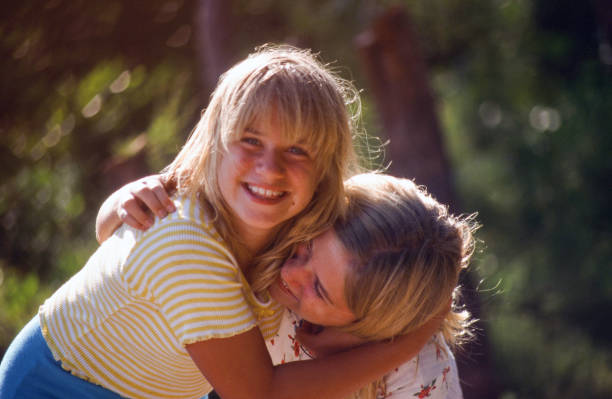 Full length of two sister embracing in the nature