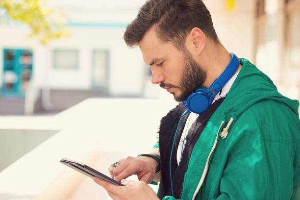 handsome man with headphones using tablet - hipster people surfing the net internet imagens e fotografias de stock