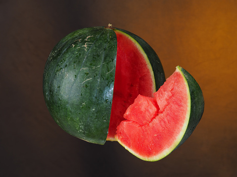 Watermelon and a slice suspended in the air.
