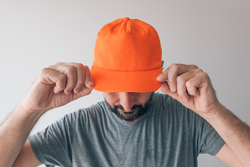 Man wearing orange baseball cap for mockup text or graphics design