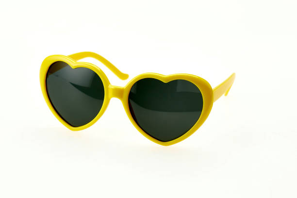 istock Heart shaped sunglasses on white background - yellow frame 1027804720