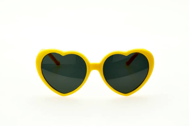 istock Heart shaped sunglasses on white background - yellow frame 1027806796