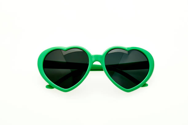 Heart shaped sunglasses on white background - green frame stock photo