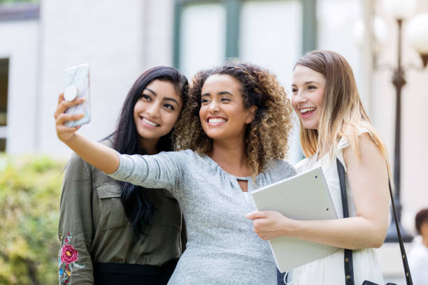 istock Smiling college girls take selfie 1027807556