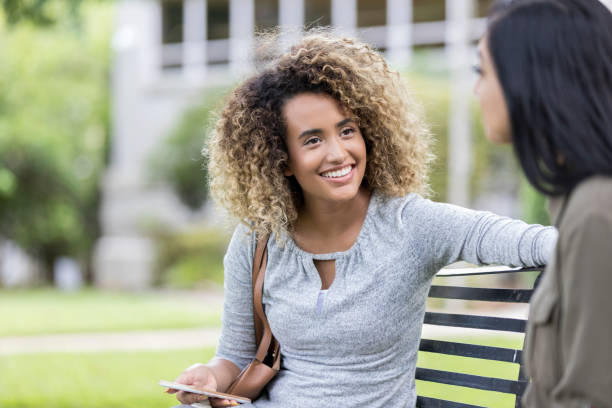 istock Cheerful college girls talk on campus 1027807572