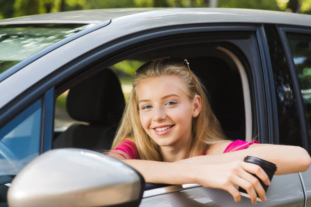 istock Girl smile with coffee cup in car 1027819896