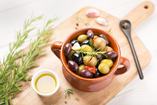 Marinated olives with garlic, rosemary, olive oil and spices. Rustic style