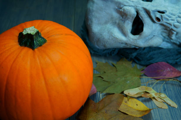 istock Pumpkin and halloween mask on old wood table 1027822640
