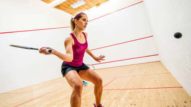 ajuste de joven jugador de squash femenino prepara para golpear la bola - squash racketball sport exercising fotografías e imágenes de stock