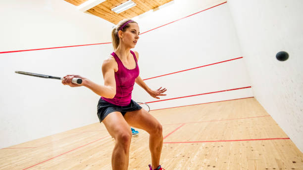 young fit female squash player preparing to hit the ball - squash racketball sport exercising imagens e fotografias de stock