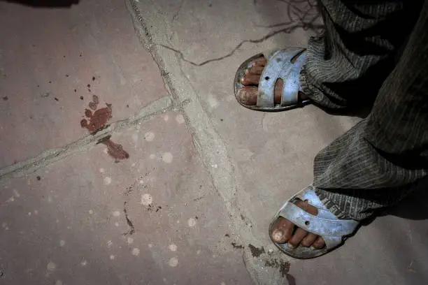 New Delhi, India: human footprint and feet of a child with sandals, out of the Jama Masjid mosque of Delhi