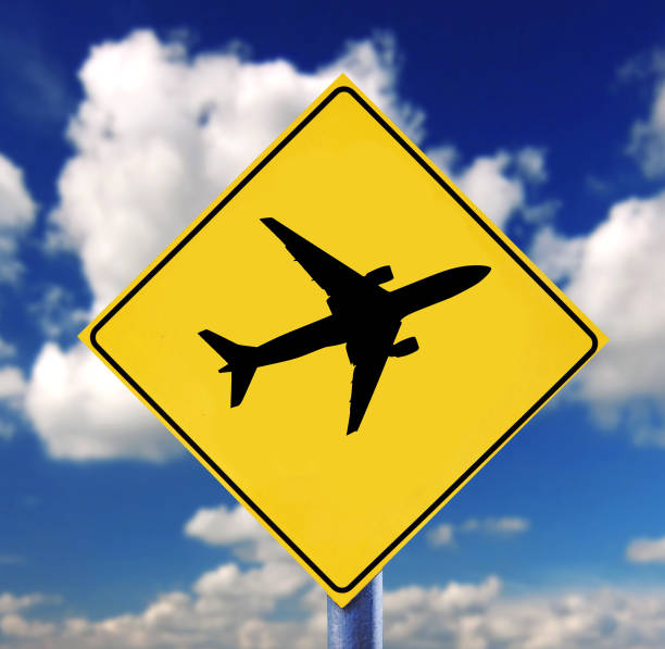istock Yellow road sign with cloudscape and airplane spictogram 1027838148