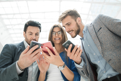 close up.business colleagues reading SMS on their smartphones. people and technology