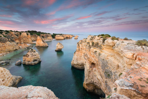Amazing landscape at sunset at Marinha Beach in the Algarve, Portugal. Amazing sunset at Marinha Beach in the Algarve, Portugal. Landscape with strong colors of one of the main holiday destinations in europe. Summer tourist attraction. benagil photos stock pictures, royalty-free photos & images