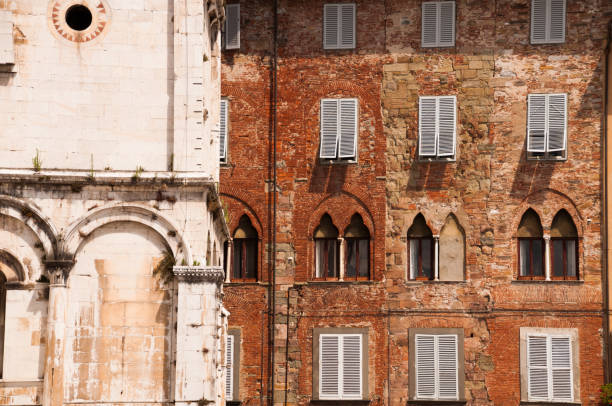Partial view of church San Michele with the facade of the surroundings buildings with brick walls and venetian windows.