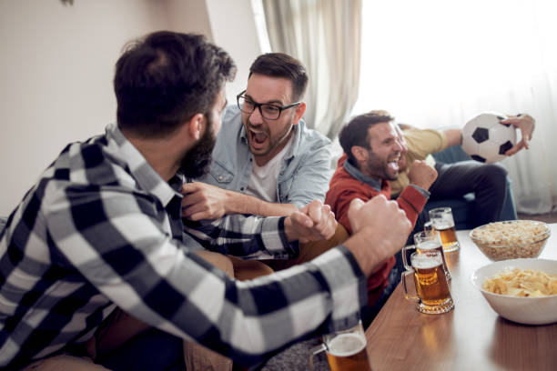 istock Soccer fans emotionally watching game on tv 1027859972