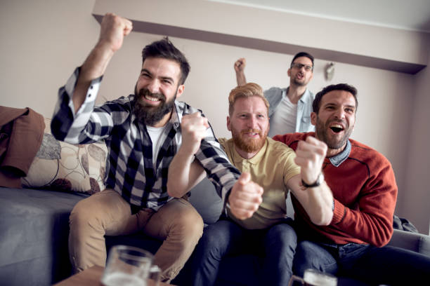 istock Soccer fans emotionally watching game on tv 1027863718