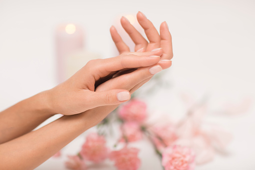 De manicura. Hermosas y delicadas manos sobre fondo blanco con flores rosas. photo