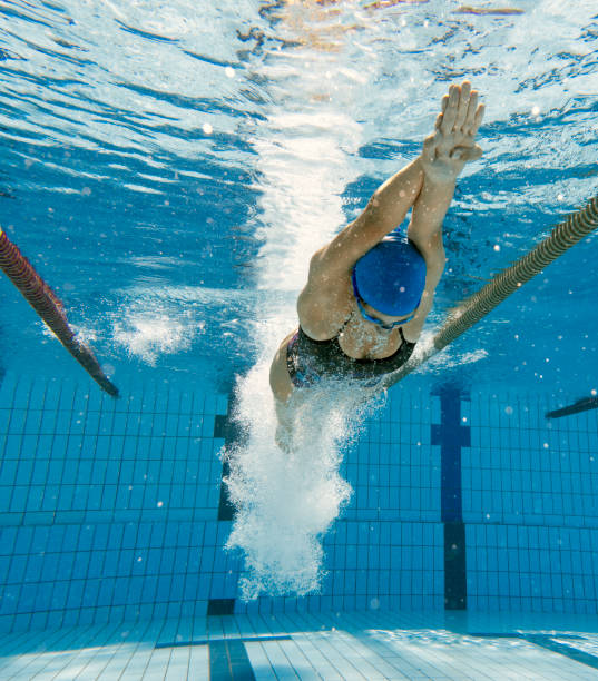 podwodny strzał młodych kobiet nurkujących w wodzie i rozpoczęcia wyścigu - women exercising swimming pool young women zdjęcia i obrazy z banku zdjęć
