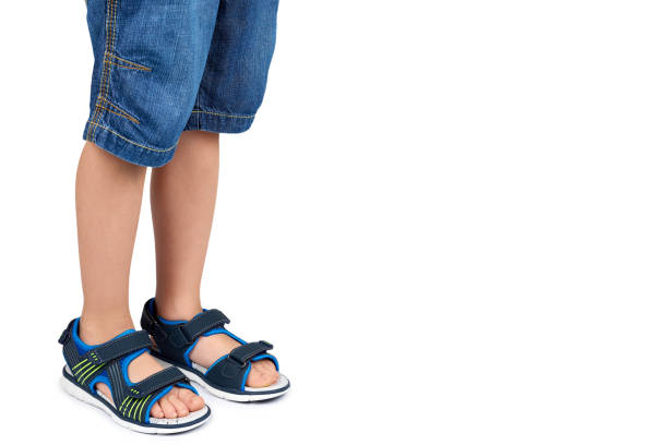 Two kids are waiting on the bench patiently. They are getting ready to go to the beach and are wearing fun pink sandals.