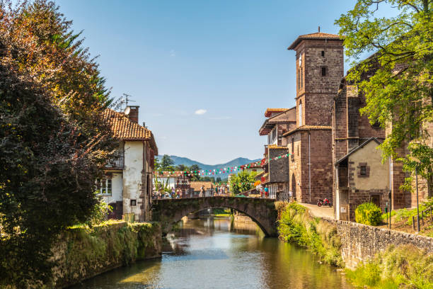 View of the river Nive on its way through the village of Saint Jean Pied de Port. France. View of the river Nive on its way through the village of Saint Jean Pied de Port and in the background the Pyrenees. France. saint jean pied de port stock pictures, royalty-free photos & images