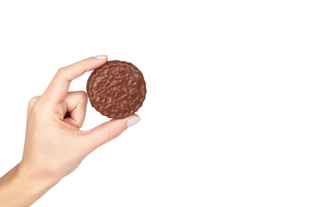 istock Chocolate cookies with cream with hand isolated on white background, copy space template 1027868196