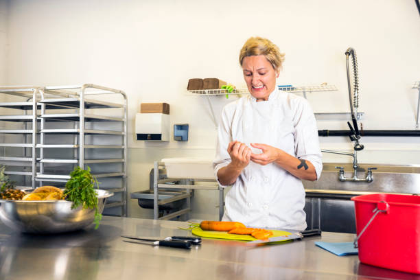 istock A female chef accidentally cuts her finger in a commercial kitchen while preparing food. 1027868698