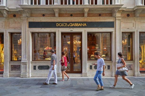 dolce and gabbana store with large windows and people walking in venice, italy - dolce & gabbana imagens e fotografias de stock