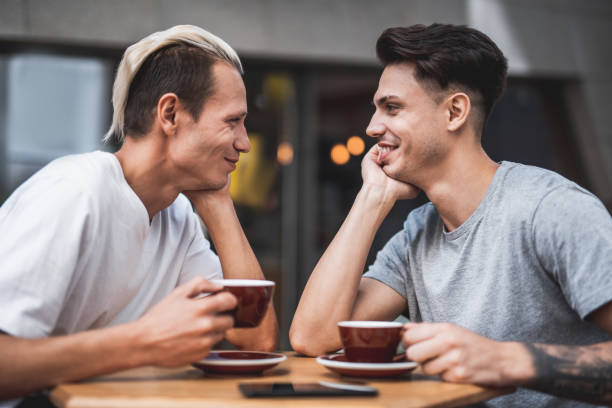 istock Satisfied friends tasting cups of coffee outdoor 1027879310