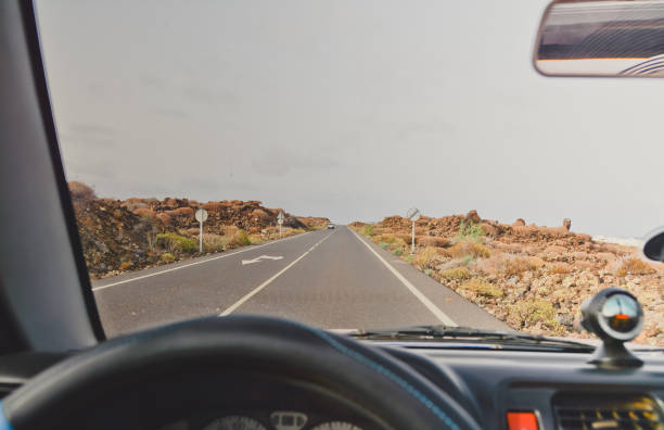istock Man driving car trough the mountains and ocean. 1027882640