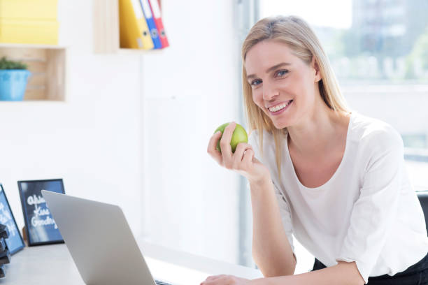 istock Businesswoman having healthy snack, eating apple 1027885708