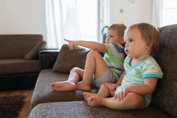istock Little brother and sister watching tv on couch 1027886206