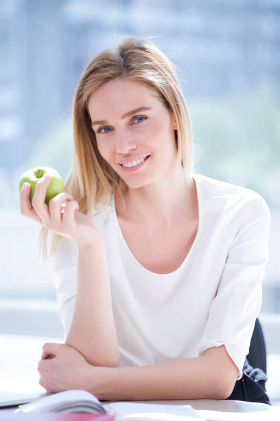 istock Blond woman, blue eyes and green apple; Nutritional value 1027889096