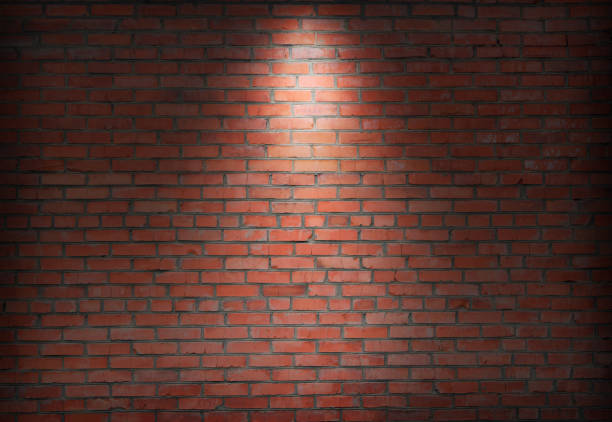 abstract old brick wall in the dark with spotlight warm light tone. abstract old brick wall in the dark with spotlight warm light tone. brick wall in empty room. brick wall background for wallpaper brick wall stock pictures, royalty-free photos & images
