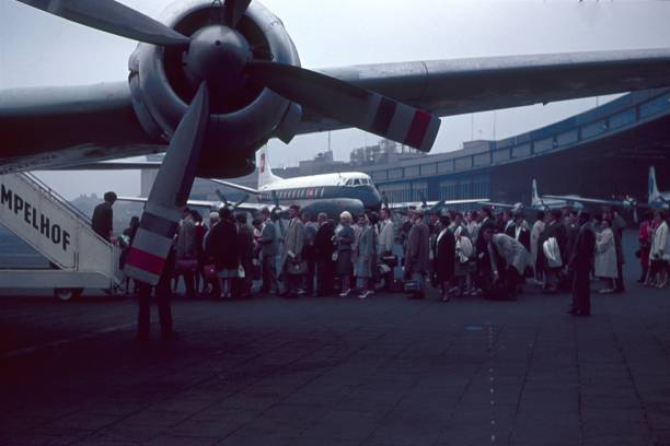 Berlin, Germany, 1962. Tempelhof Airport. Boarding. Passengers stand in front of the gangway waiting to get on the plane.