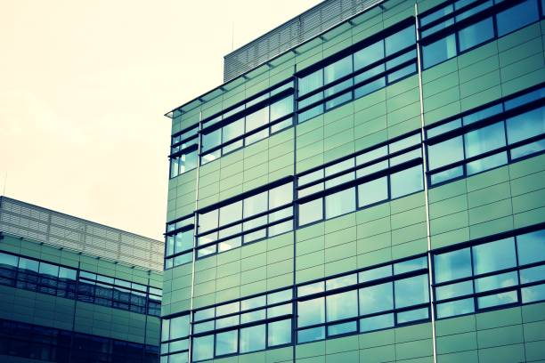 istock Modern office building on a clear sky background. Retro stylized colorful tonal filter effect 1027909534