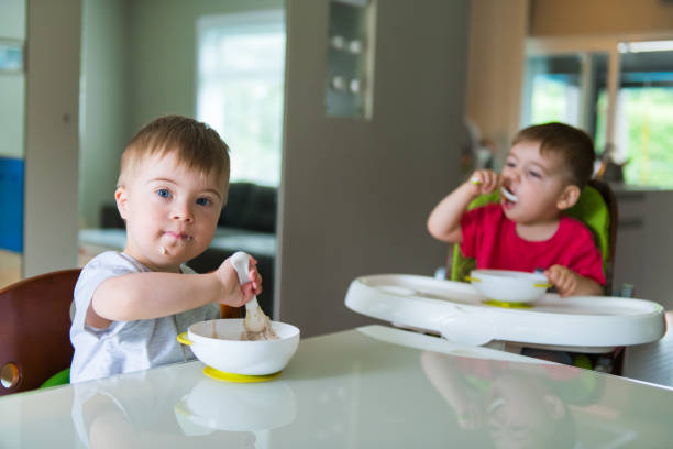 istock Down's Syndrome sweet boy eating breakfast with his brother 1027929600