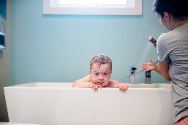 istock Down's Syndrome sweet boy in the bath while Mom is washing him. 1027932778