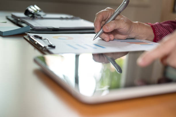 istock financial inspector analyze document at office. woman working with tablet at workplace 1027943520