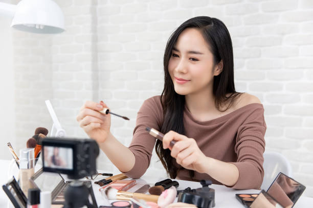 istock Asian woman beauty vlogger doing cosmetic makeup tutorial video 1027945630