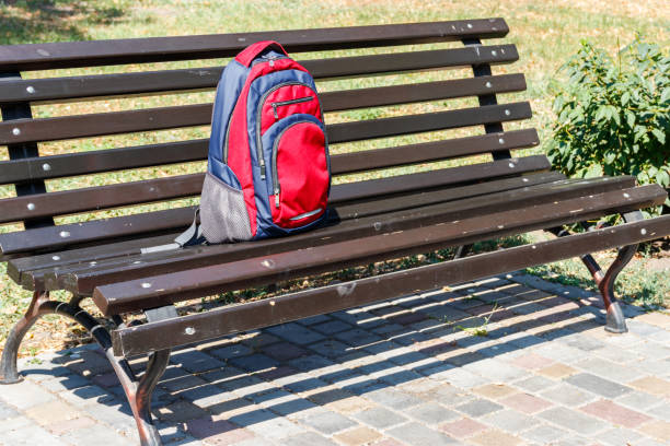 istock Backpack on wooden bench in city park 1027948608
