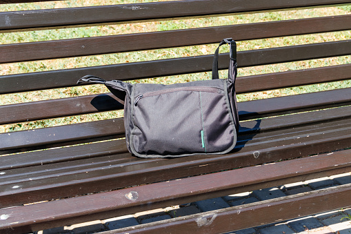 Bag on wooden bench in city park