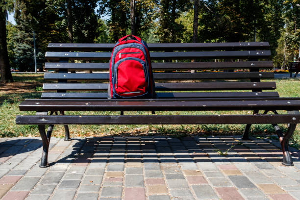 istock Backpack on wooden bench in city park 1027948634