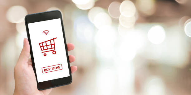 istock Hand holding smart phone with shopping online device on screen over blue background with copy space, business and technology, online shopping concept 1027956064