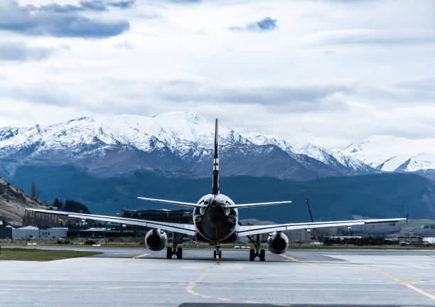 un aereo con lo sfondo della neve di montagna. - runway airport airfield asphalt foto e immagini stock